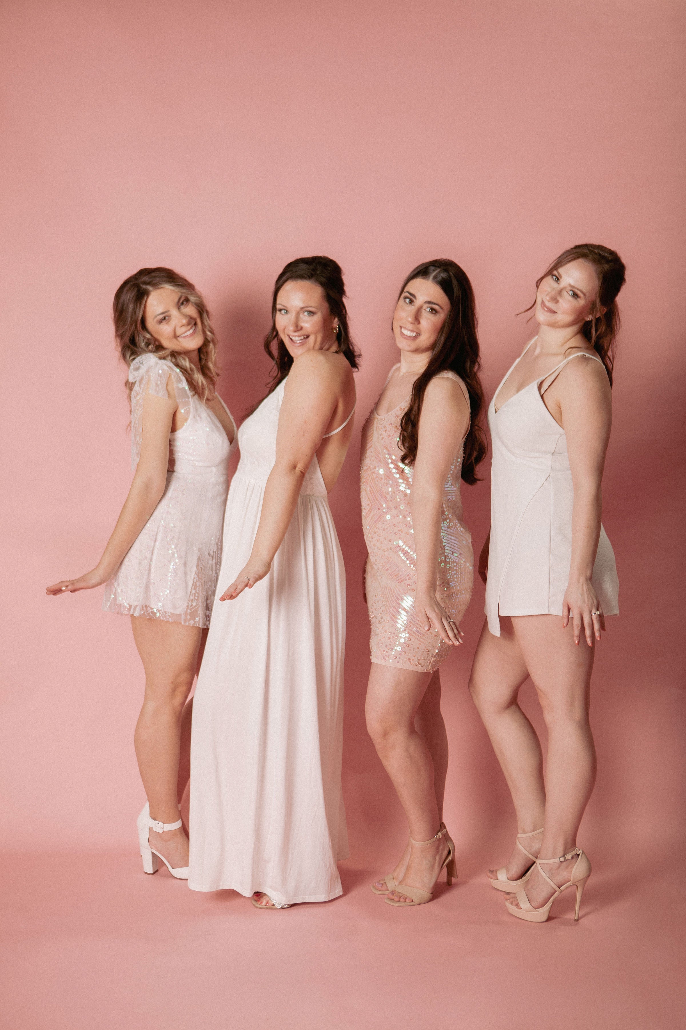 group of women in dresses with pink background